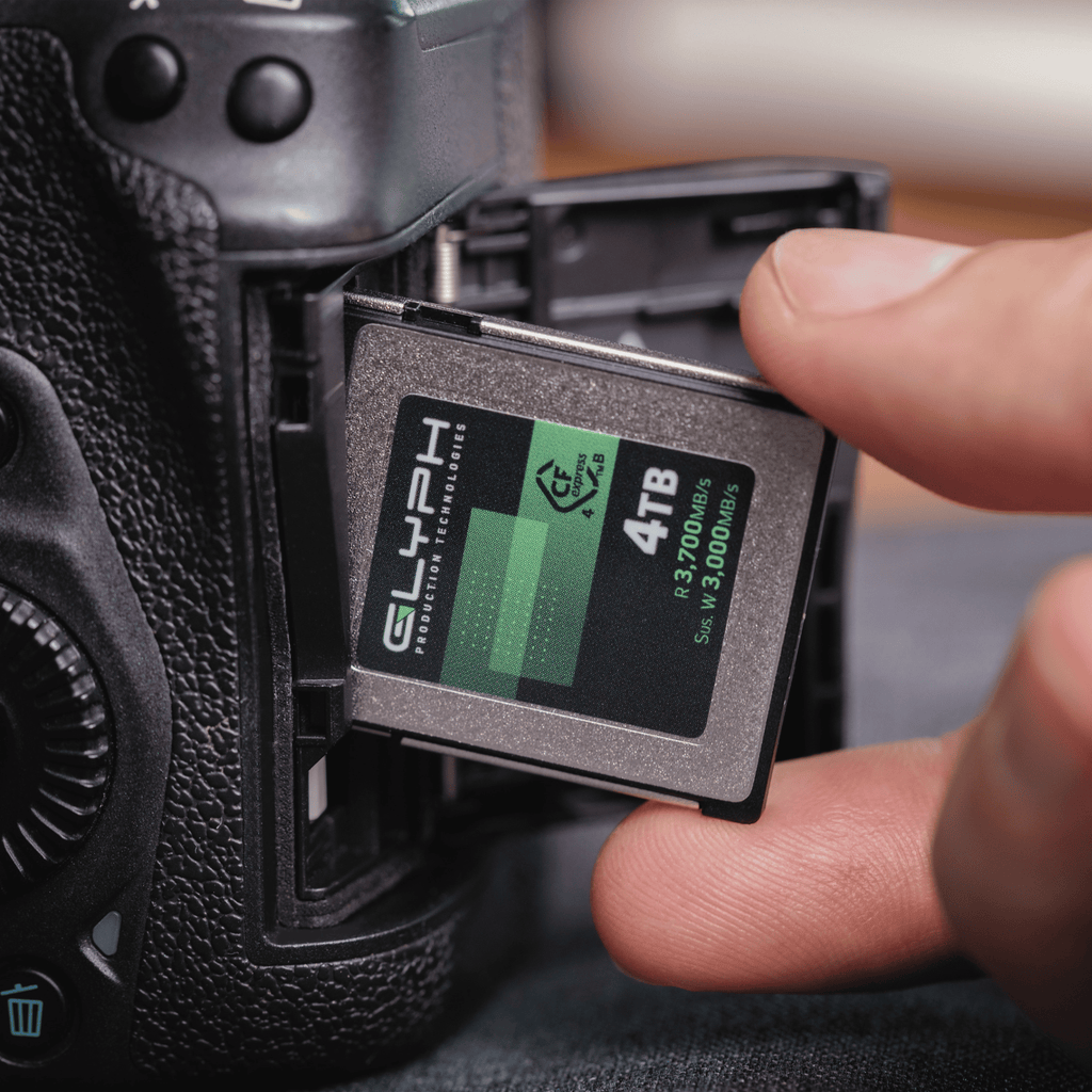 Person inserting a 4TB Glyph memory card into a camera