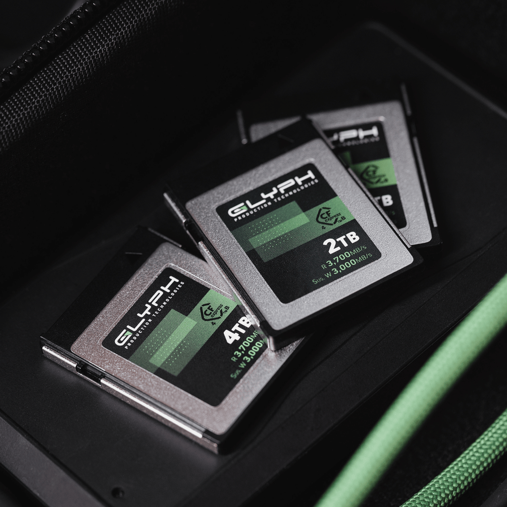 Three Glyph memory cards with green and black labels on a dark surface.
