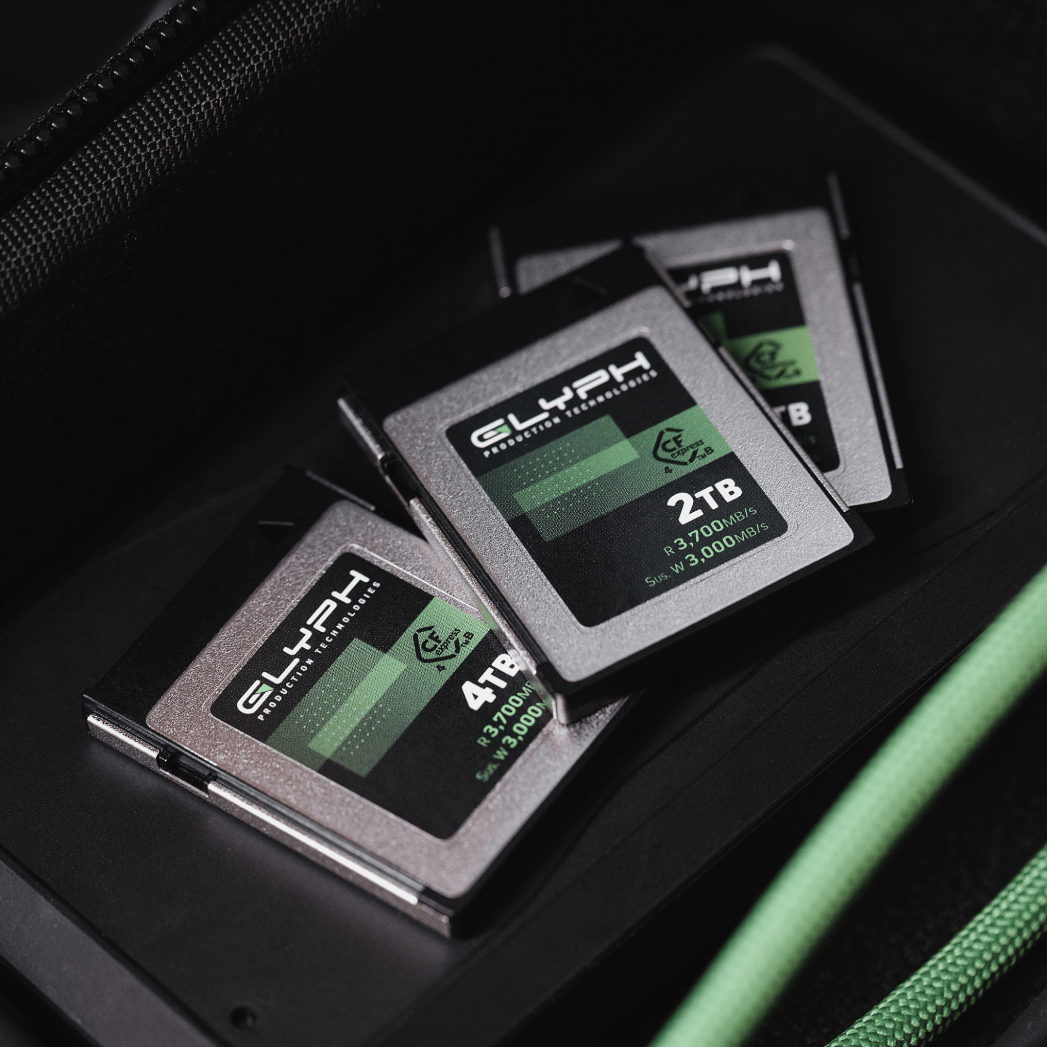 Three Glyph memory cards with green and black labels on a dark surface.